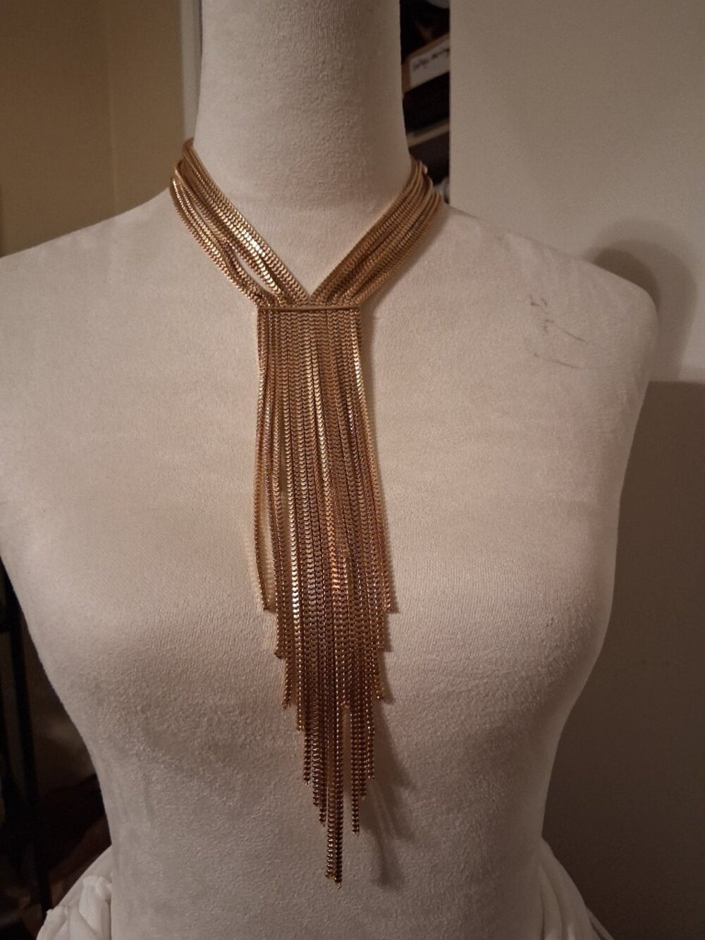 Gold tone, multistrand, snake chain, fringe necklace. The brand is NY.